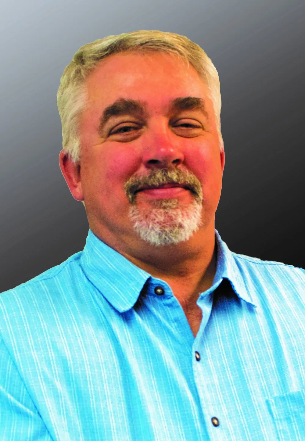 Sam Baird, REALTOR®, smiling in a light blue shirt